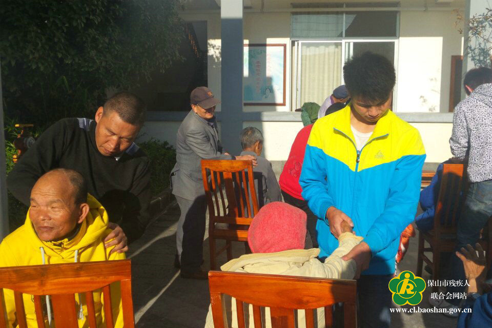 图为残疾人按摩组正在为老人进行保健按摩