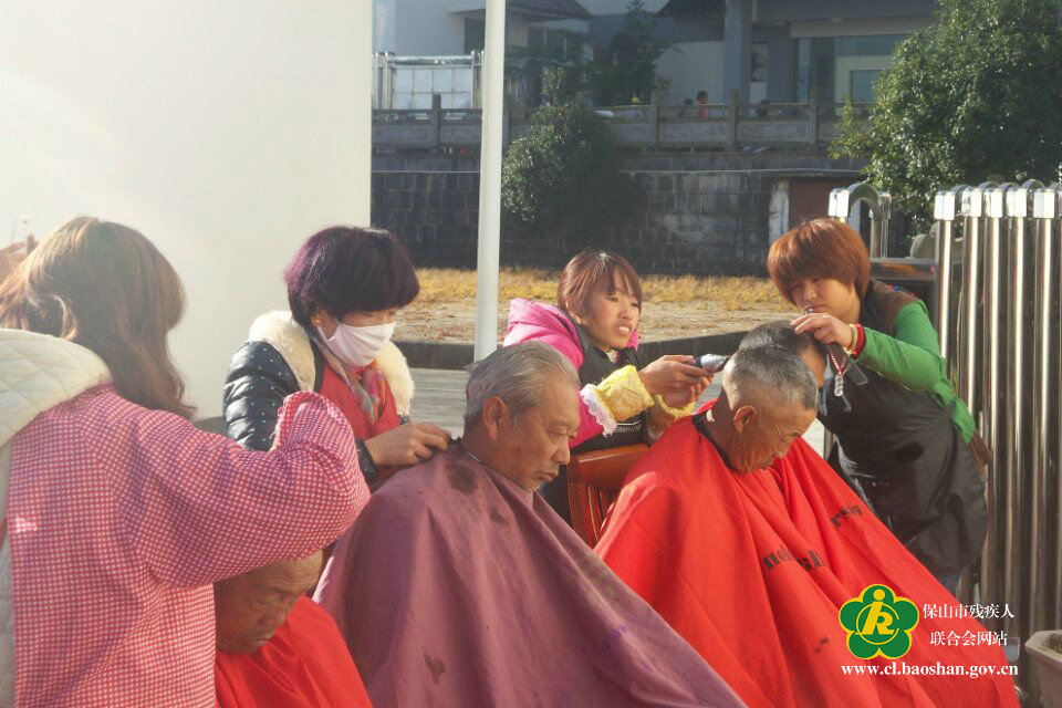 图为残疾人理发组正在为老人理发