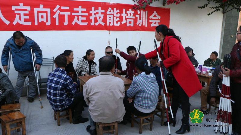 图为:康复人员为视力残疾人配发盲杖